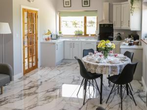 a kitchen with a table with a vase of flowers on it at Ballyboy View in Manorhamilton