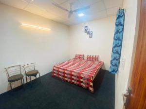 TanakpurにあるLUSHY DAYS BOOM CAMPのベッド1台と椅子2脚が備わる客室です。