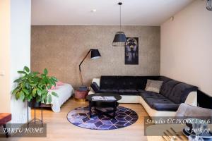 a living room with a black leather couch at University City Heart, Tartu Home in Tartu