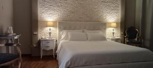 a bedroom with a large white bed and two chairs at Hotel Palladium in Monastir