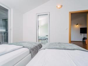 two beds in a white room with a window at Apartment Jagoda Okrug Gornji in Trogir