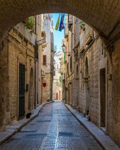 an alley in an old town with an archway at A casa di Fiore, holiday home in Giovinazzo
