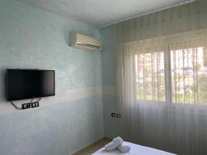 um quarto com uma televisão de ecrã plano na parede em 1-Stunning Sea View Apartments! em Saranda