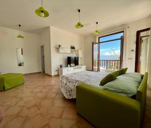 um quarto com uma cama e uma grande janela em La Badia Montechiaro - Breathtaking View of Sorrento Coast em Vico Equense