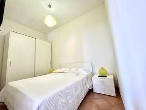 um quarto com uma cama branca e um armário branco em La Badia Montechiaro - Breathtaking View of Sorrento Coast em Vico Equense