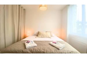 1 dormitorio con 1 cama con 2 toallas en Havre de paix au cœur de la ville en Ay