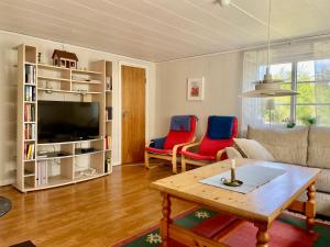 a living room with a couch and a table and chairs at Holiday home Småland Gäddegölshult in Gäddegölshult