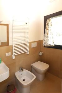 a bathroom with a toilet and a sink and a window at Ca' del Portego in Tessera