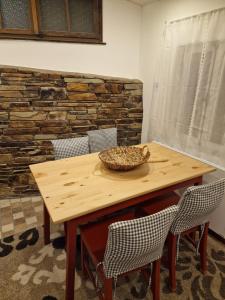 una mesa de madera con sillas y un tazón. en Fachwerkhaus Hänsel und Gretel, en Hundsdorf