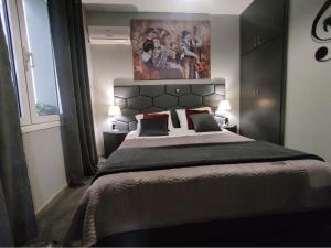 1 dormitorio con 1 cama grande y una pintura en la pared en Music Reflections Apartment near Nafplio, en Nea Kios