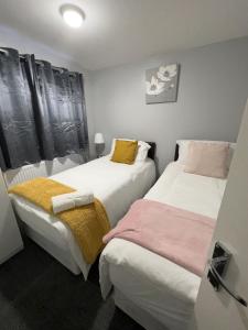 two beds sitting next to each other in a room at Mona's Home in Dagenham
