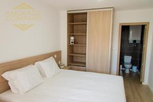 a bedroom with a white bed and a bathroom at Refúgio da Suite 4 in Pinhão