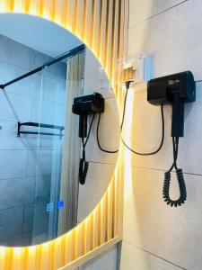 ein Bad mit einem Spiegel und einem Telefon in der Unterkunft Cozy Ocean View APT in KK City Center in Kota Kinabalu