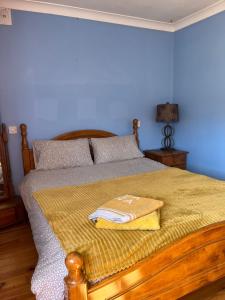 graiguenamanagh Homestay في Graiguenamanagh: غرفة نوم عليها سرير وفوط صفراء