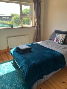 graiguenamanagh Homestay في Graiguenamanagh: غرفة نوم عليها سرير وبطانية زرقاء