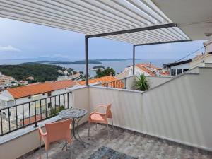 eine Terrasse mit einem Tisch und Stühlen auf dem Balkon in der Unterkunft BenJak Apartments in Hvar