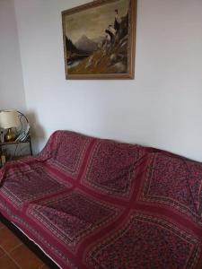 eine Couch in einem Wohnzimmer mit einer Decke drauf in der Unterkunft Casa Isabella II, trilocale in Erbezzo in Erbezzo