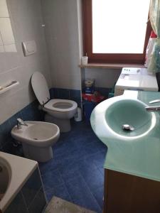 ein Badezimmer mit einem weißen WC und einem Waschbecken in der Unterkunft Casa Isabella II, trilocale in Erbezzo in Erbezzo