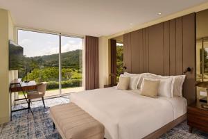 a bedroom with a large white bed and a large window at Penha Longa Resort in Sintra