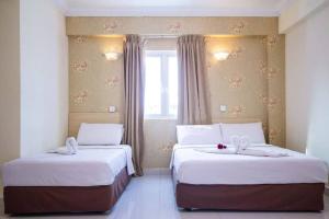 Hotel Sea Princess في تيلوك بهانج: سريرين في غرفة الفندق مع نافذة