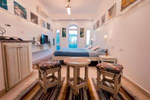 a bedroom with a bed and two stools at Skyrock Dahab in Dahab