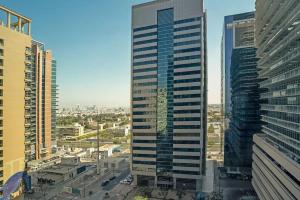 a tall skyscraper in the middle of a city at GREAT 3 Bedroom Apartment Beach Front (Side View) in Abu Dhabi