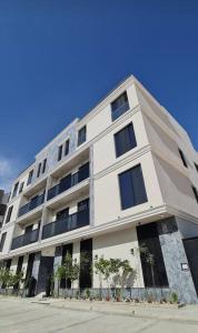 a large white building with trees in front of it at Paradise of North Riyadh جنة شمال الرياض in Riyadh