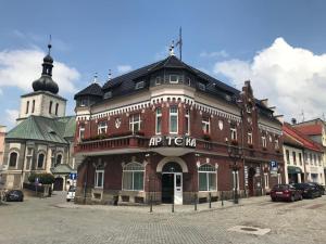 a large red brick building with a clock tower at Pokoje W Pięknej Kamienicy W Centrum W Głogówku in Głogówek