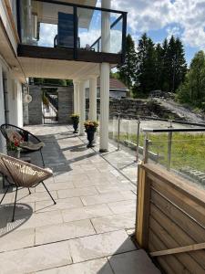 um pátio com um deque com uma cadeira e uma varanda em Apartment in Åsane em Bergen