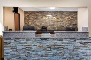 a bar in a restaurant with a brick wall at Baymont by Wyndham Joliet in Joliet