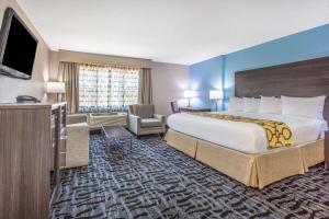 ein Hotelzimmer mit einem großen Bett und einem TV in der Unterkunft Baymont by Wyndham Joliet in Joliet