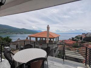 a table and chairs on a balcony with a view of the water at Apartment Ain Naum in Ohrid
