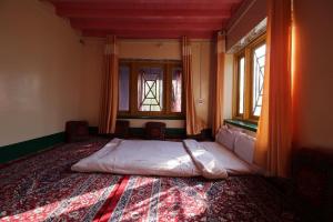 a bedroom with a bed in a room with windows at OYO Flagship 4945 AR LODGE in Srinagar