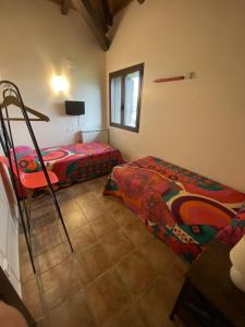 1 dormitorio con 2 camas, mesa y ventana en O Zierzo en Jaca