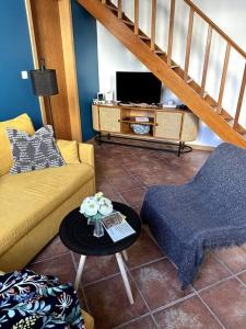 a living room with a couch and a table with a tv at Apartamento das Fontes in Furnas