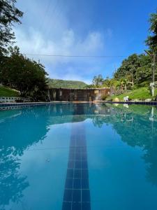 une grande piscine d'eau bleue avec des arbres en arrière-plan dans l'établissement Eco Flat 314 - Hotel Fazenda Pedra do Rodeadoro, à Bonito