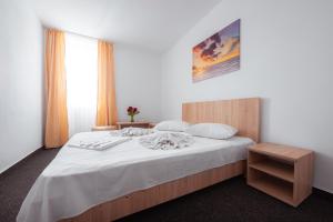 - une chambre avec un grand lit et des draps blancs dans l'établissement Hotel Nadia Eforie Nord, à Eforie Nord