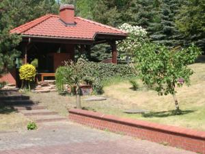 um gazebo com um banco num quintal em Apartament II Marysieńka em Kąty Rybackie