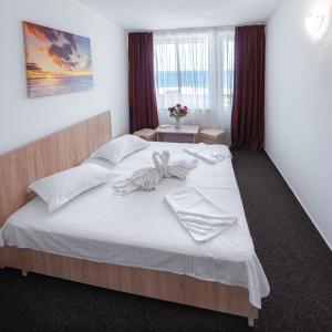 1 dormitorio con 1 cama grande con sábanas blancas en Hotel Nadia Eforie Nord, en Eforie Nord