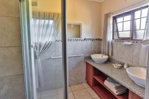 y baño con ducha y lavamanos. en Zuider Zee Guest House en Ballito