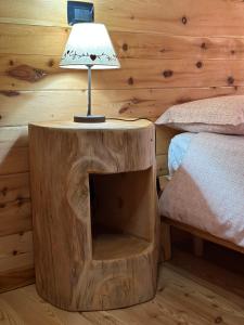 a lamp on a wooden table in a bedroom at LA PIANA DAL SAS in Gravellona Toce