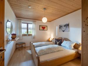 a bedroom with two beds and a wooden ceiling at Berggasthof Bichlersee in Oberaudorf
