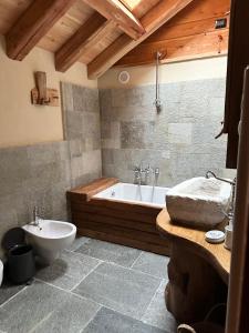 een badkamer met een bad, een toilet en een wastafel bij LA PIANA DAL SAS in Gravellona Toce