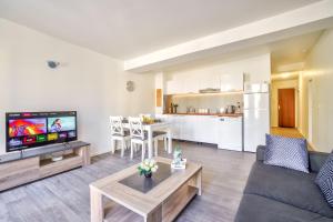 a living room with a couch and a table at Top Destination Pontoise in Pontoise