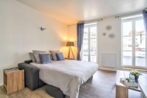 een slaapkamer met een bed en een groot raam bij Top Destination Pontoise in Pontoise