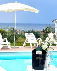 a bottle of wine in a bucket next to a pool at Vigneto - Italian Restaurant & B&B in Villa Rosa