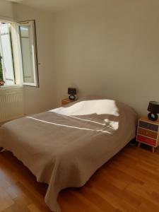 a bed in a white room with a window at LA ROCHELLE classé 3 étoiles in Nieul-sur-Mer