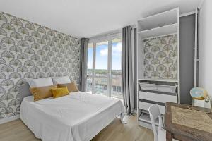 - une chambre avec un lit et une grande fenêtre dans l'établissement Le Jolimont T4 et vues spectaculaires sur la ville, à Toulouse