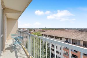 - un balcon avec une chaise bleue dans un bâtiment dans l'établissement Le Jolimont T4 et vues spectaculaires sur la ville, à Toulouse