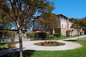 a walkway in front of a building with flowers at TownePlace Suites San Jose Cupertino in San Jose